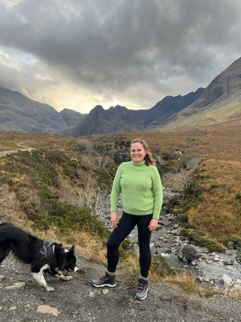 Woman stands in national park smiling 