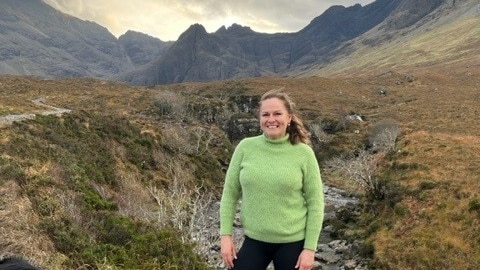 Woman stands in national park smiling 