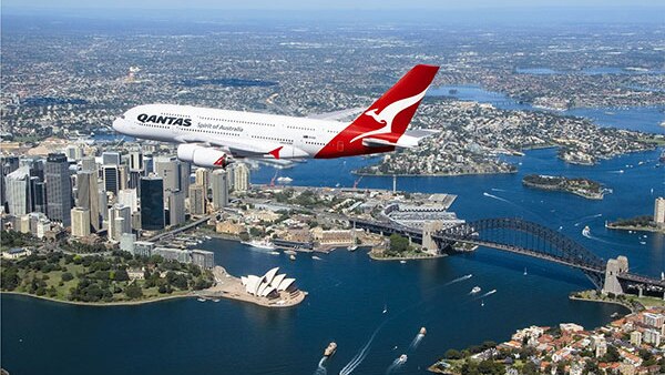 A plane flies over Sydney.