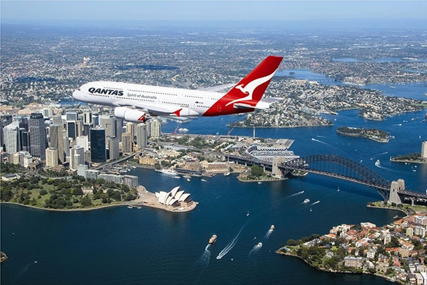 A plane flies over Sydney.