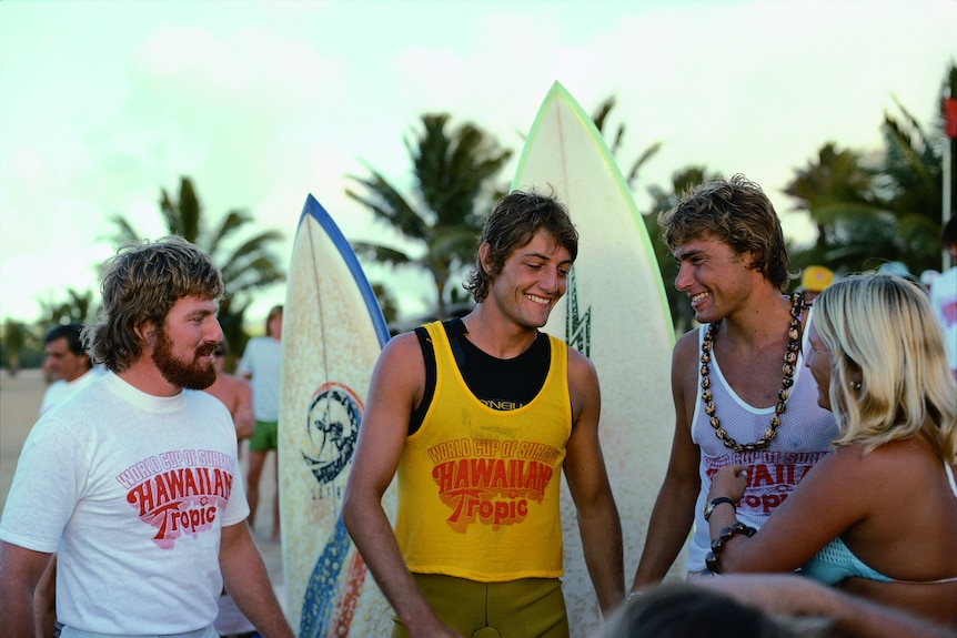 Shaun Tomson greets a fan on the beach after a surfing event.