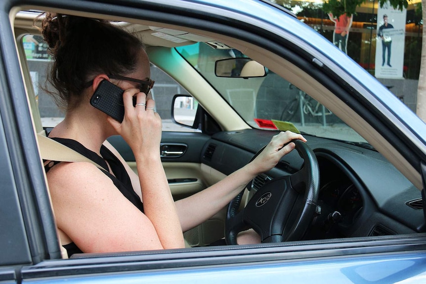 A women on a mobile phone while driving her car in Brisbane.