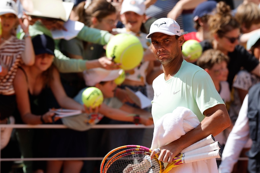Rafael Nadal walks with a crowd behind him