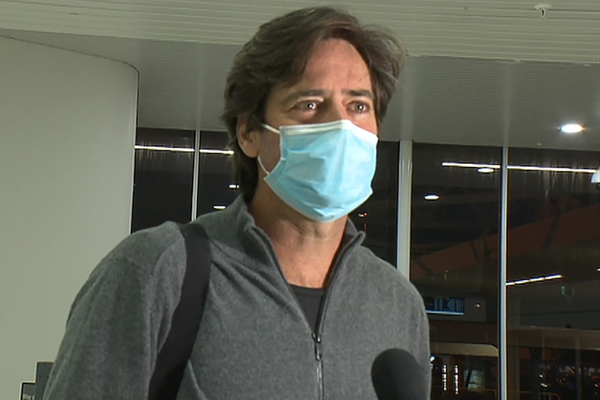 A head and shoulders shot of Gillon McLachlan speaking and wearing a face mask.