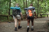 Two men walking with backpacks on in a nature setting