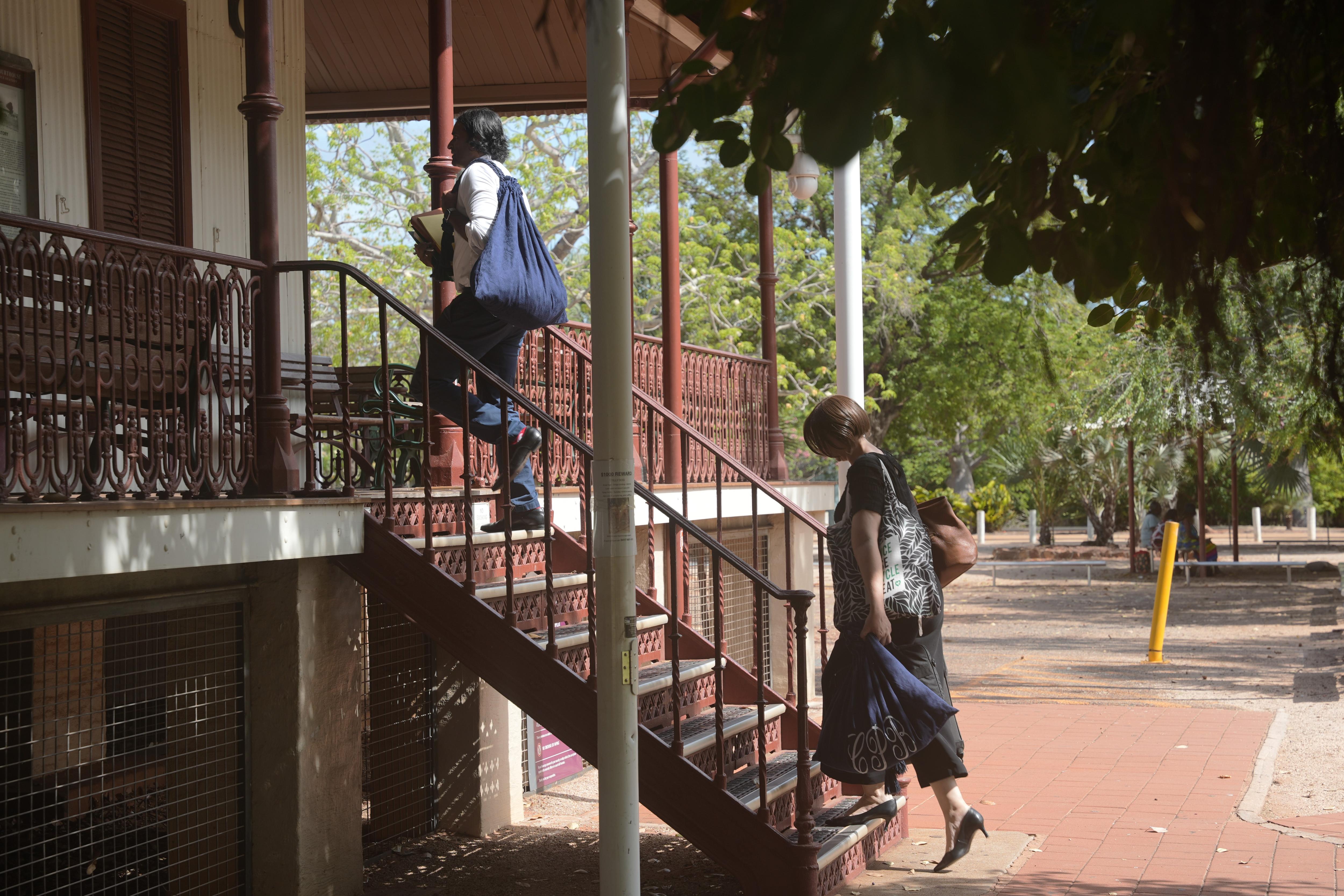two lawyers walking up steps of a court house 