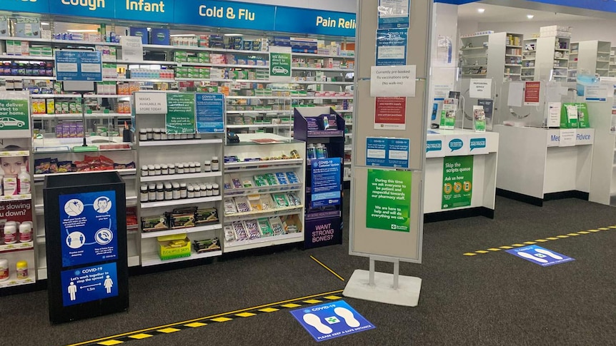 Chemist counter with coronavirus information and queues marked out.