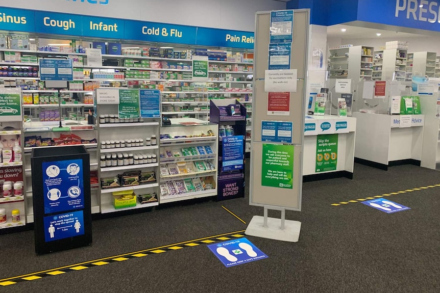 Chemist counter with coronavirus information and queues marked out.