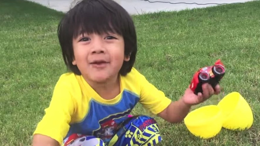 Ryan sits in his backyard and reviews a toy car.