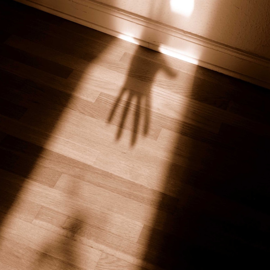 Frightening shadow of hand in doorway