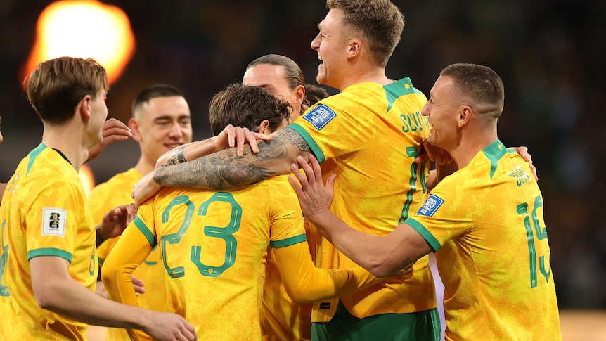 Harry Souttar of the Socceroos celebrates scoring a goal with teammates.