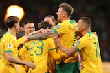 Harry Souttar of the Socceroos celebrates scoring a goal with teammates.