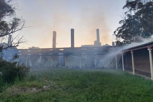 Image of building partially destroyed by fire. Smoke covering much of building.