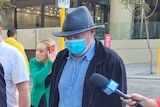 Douglas William McCarthy leaves court wearing a COVID mask.