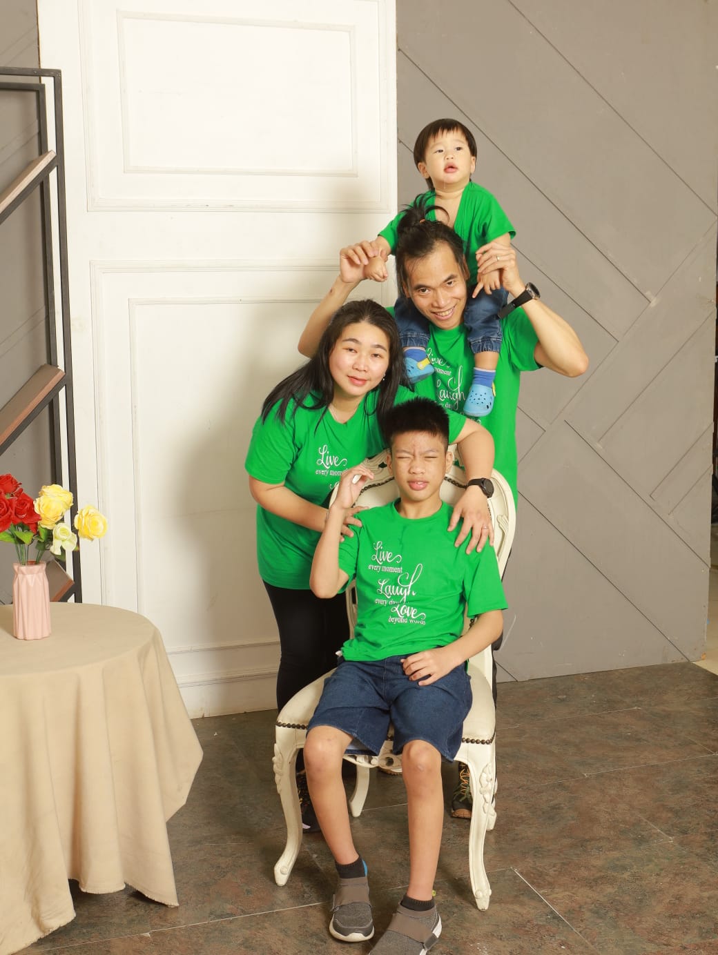 A man and woman pose for a photo with their two sons