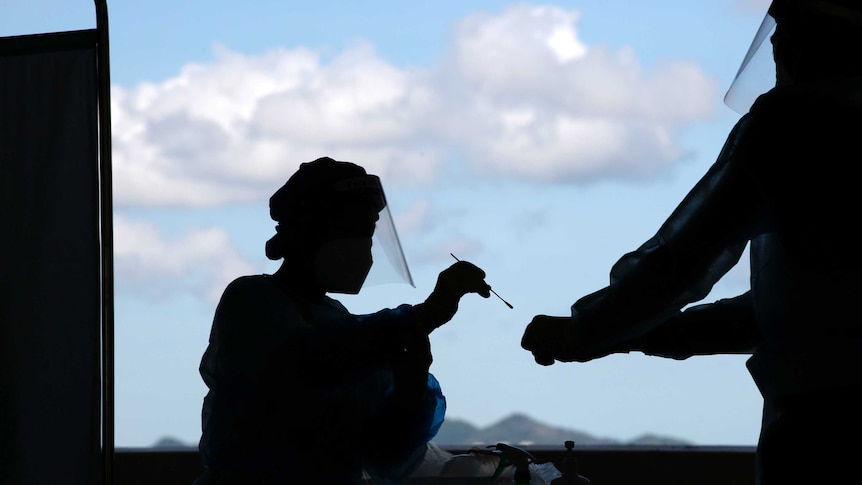 A health worker puts a swab sample into a container for COVID-19 test.