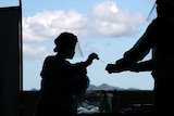 A health worker puts a swab sample into a container for COVID-19 test.