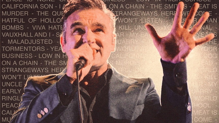 The Smiths singer sings live with his arm outstretched against a backdrop of song titles he's written