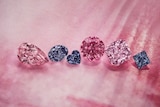 A close up of six pink, violet and red diamonds against a pink background