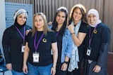 Five women, some wearing headscarves, who volunteer for the community care kitchen.