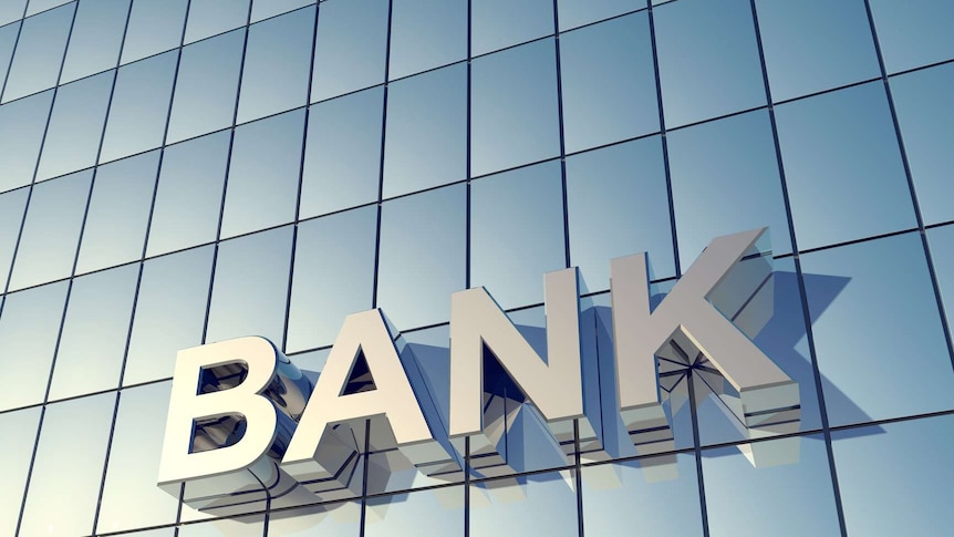 This image focusses on the shiny, blue-toned glass front of a building, and zooms in on the word "bank".