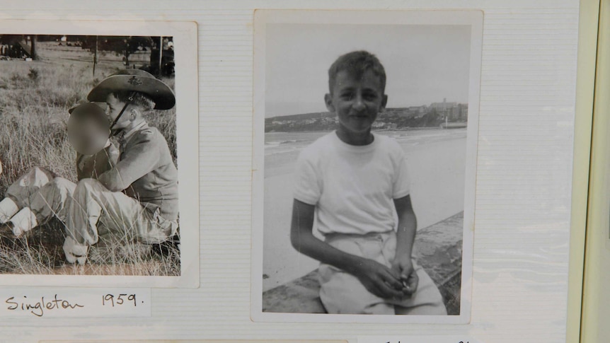 An old photo album shows black-and-white pictures of a young boy.