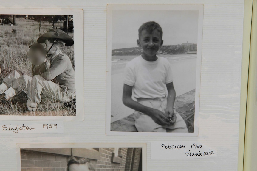 An old photo album shows black-and-white pictures of a young boy.