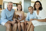 Former rugby league player and coach Paul Green, sitting on a couch his children Emerson and Jed, and his wife Amanda