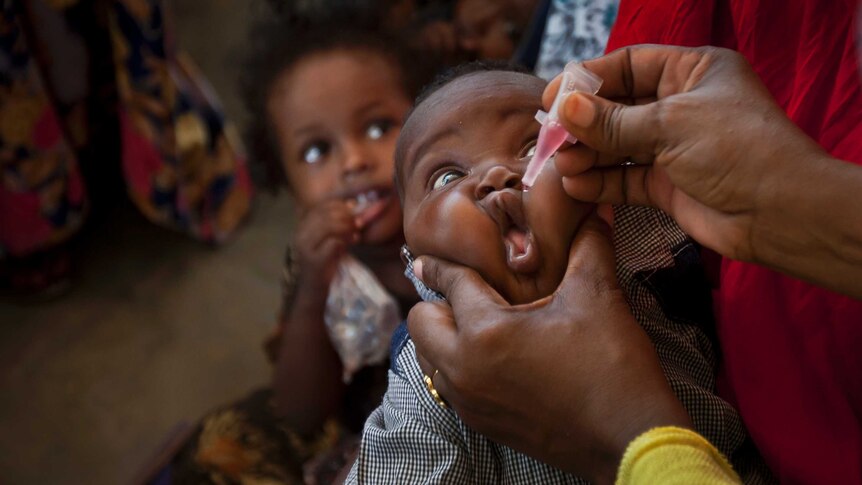 Somali baby gets his face squeezed as he receives a polio vaccine at the Medina Maternal Child Health centre in Mogadishu.