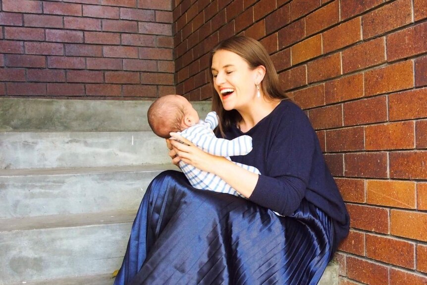 Jasmine Hunt with her newborn son sitting on some steps