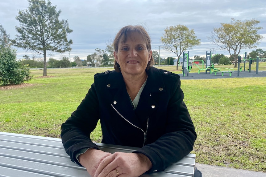 Photo of a woman at a table outside.