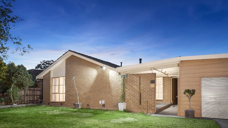 A brick house with the porch lights on.