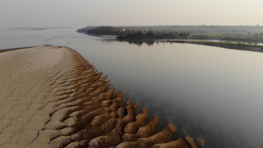 A rippled sand bank disappearing into the still Ayeyarwady River
