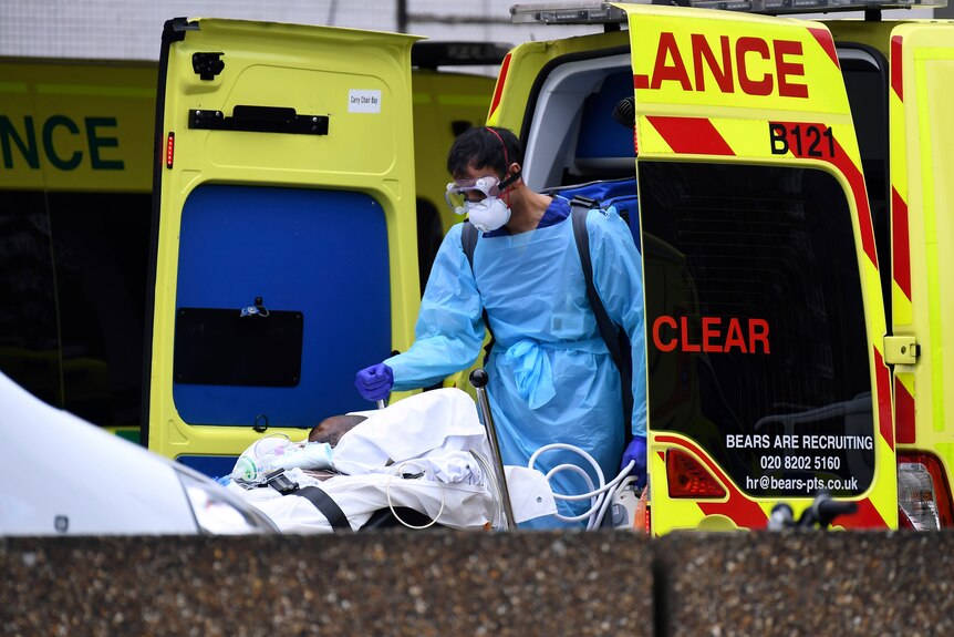 A medical worker attends to a patient in an ambulance.