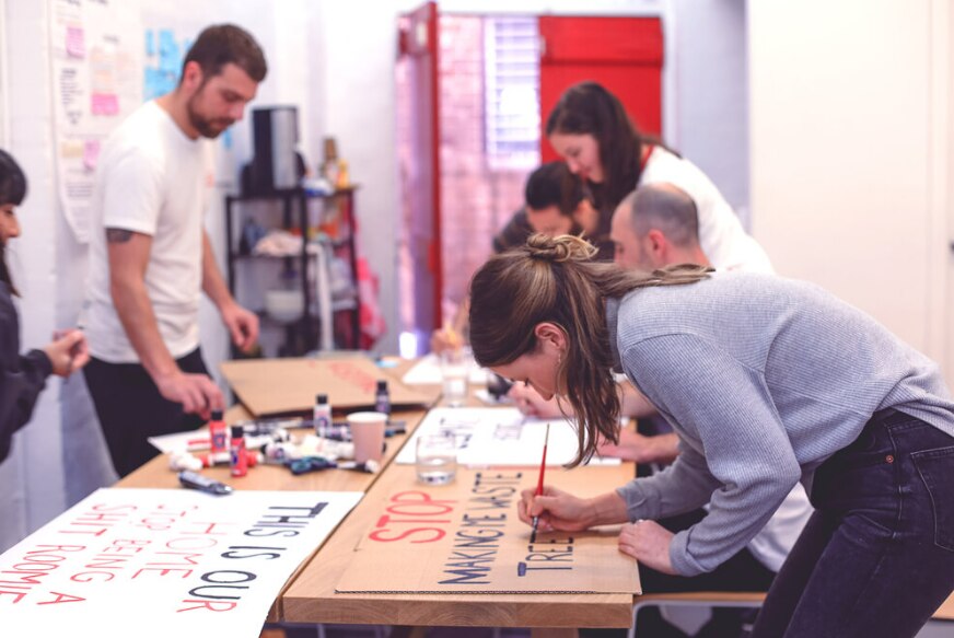 Several people write slogans on placards.