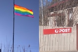 A rainbow flag and an Australia Post sign