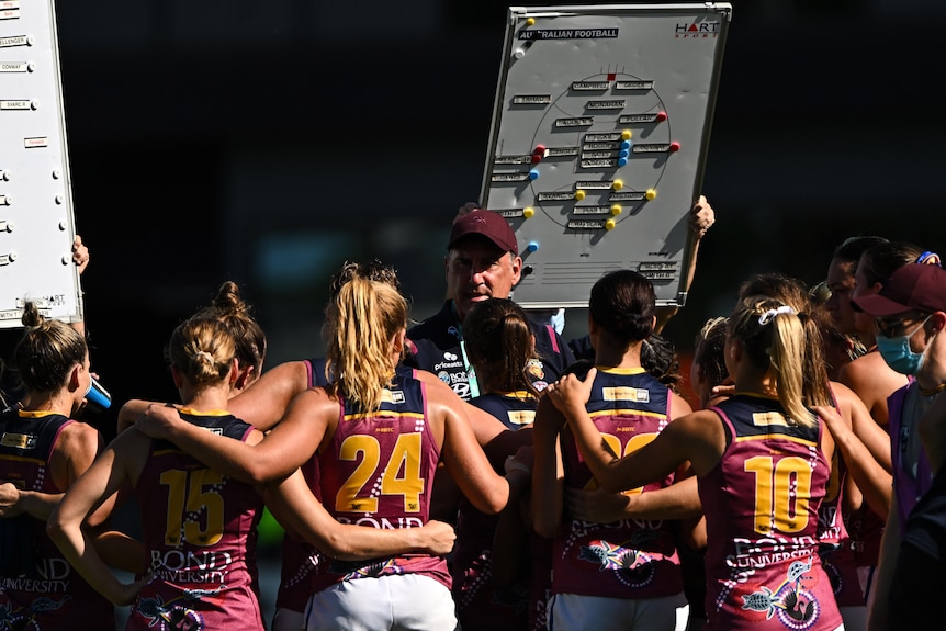 Craig Starcevich addresses Lions players in front of a whiteboard with magnets