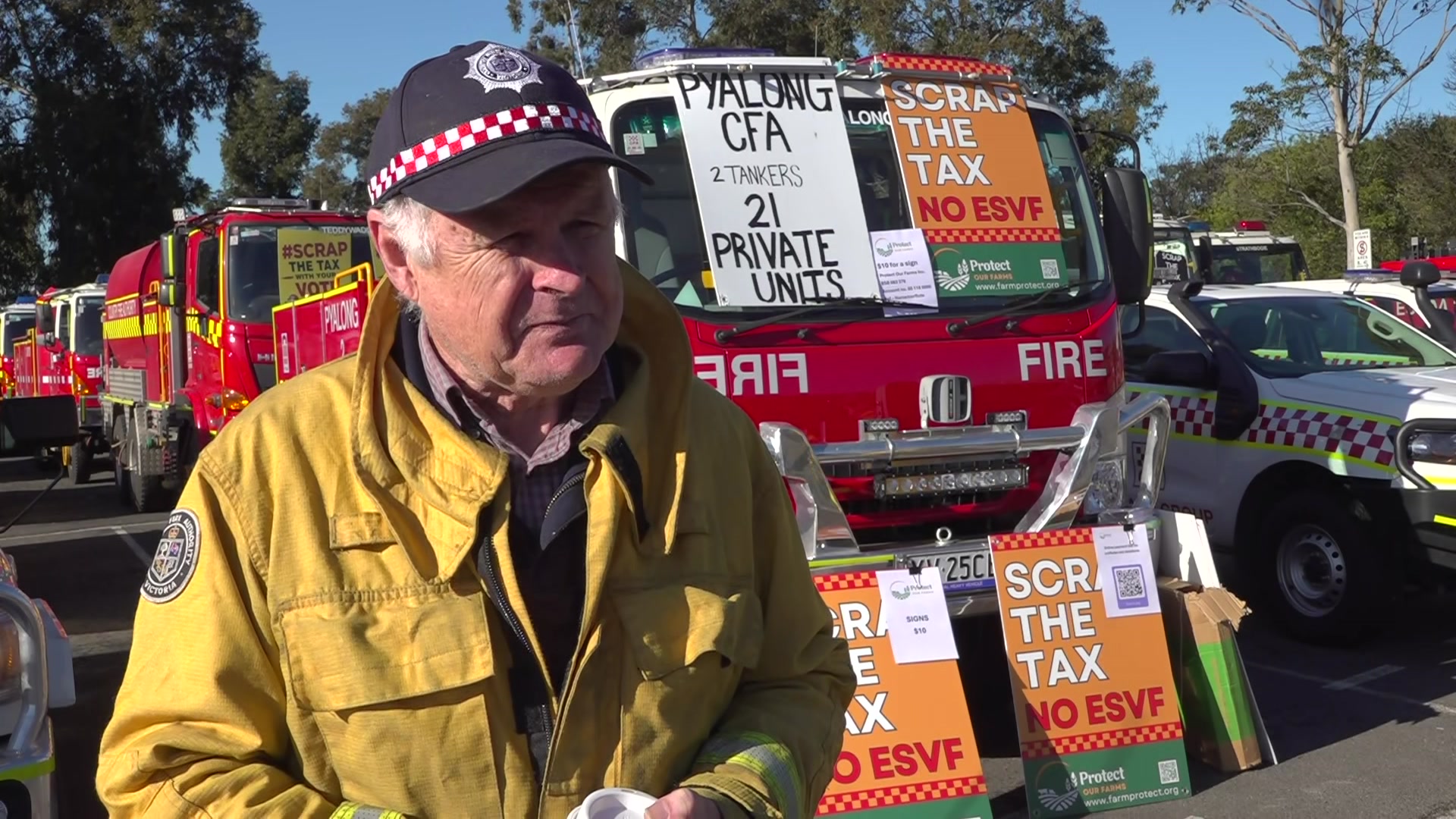 Chris Cooke wears yellow CFA jacket and is standing in front of a fire truck.