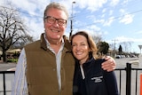 Alexander Downer smiling on the left with daughter Georgina standing to his right with his arm around her.