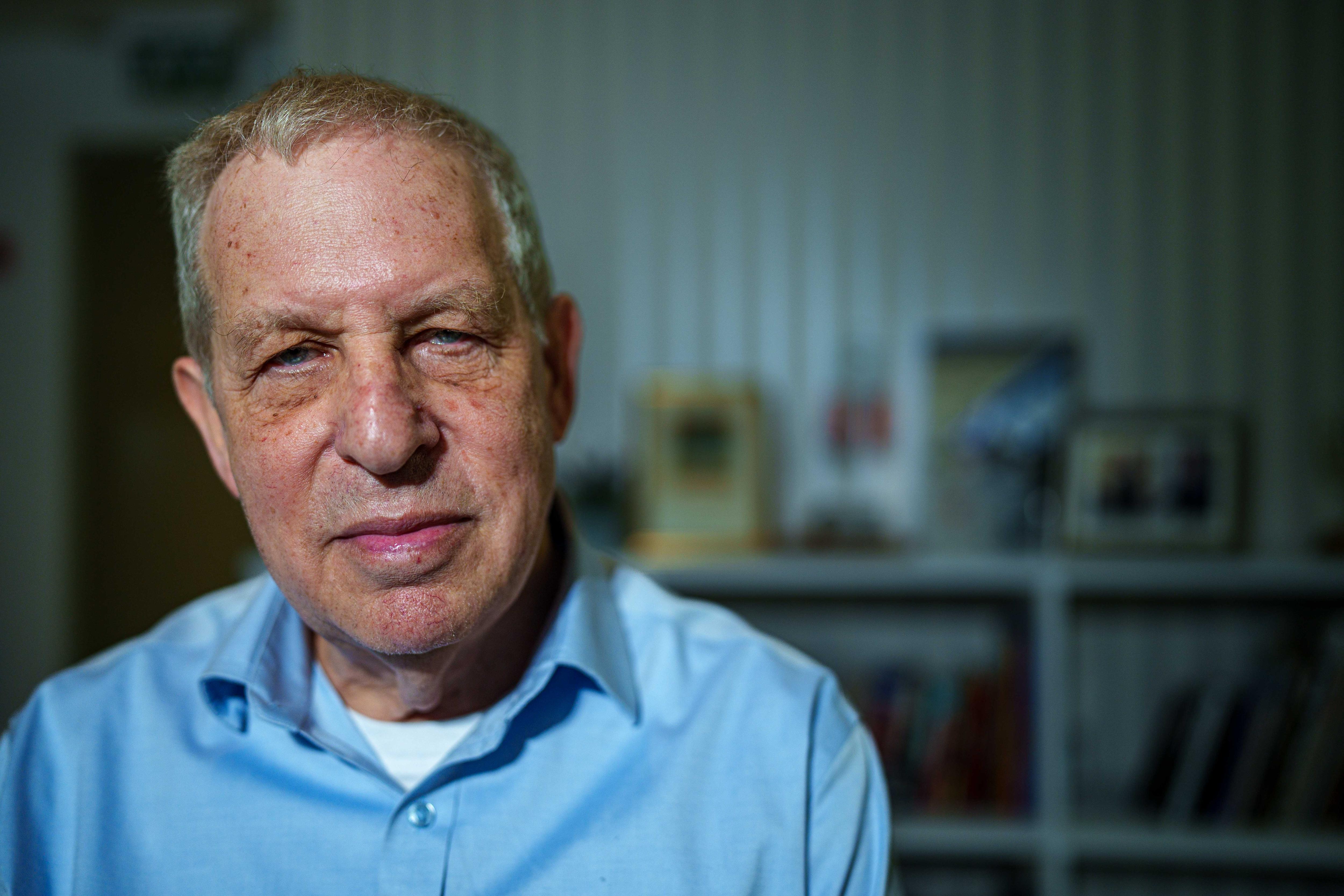 Giora Eiland looks into the camera while wearing a blue, button-up shirt.