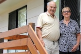 Man and woman on front stairs of a house