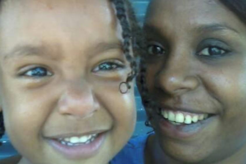 A woman and her son smile at the camera