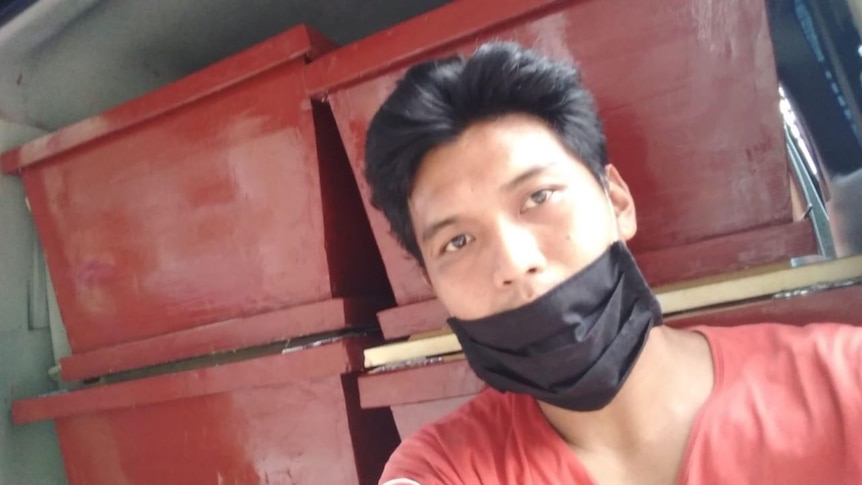 A phot of Ari Rusmawan wearing a black mask and red t-shirt. 