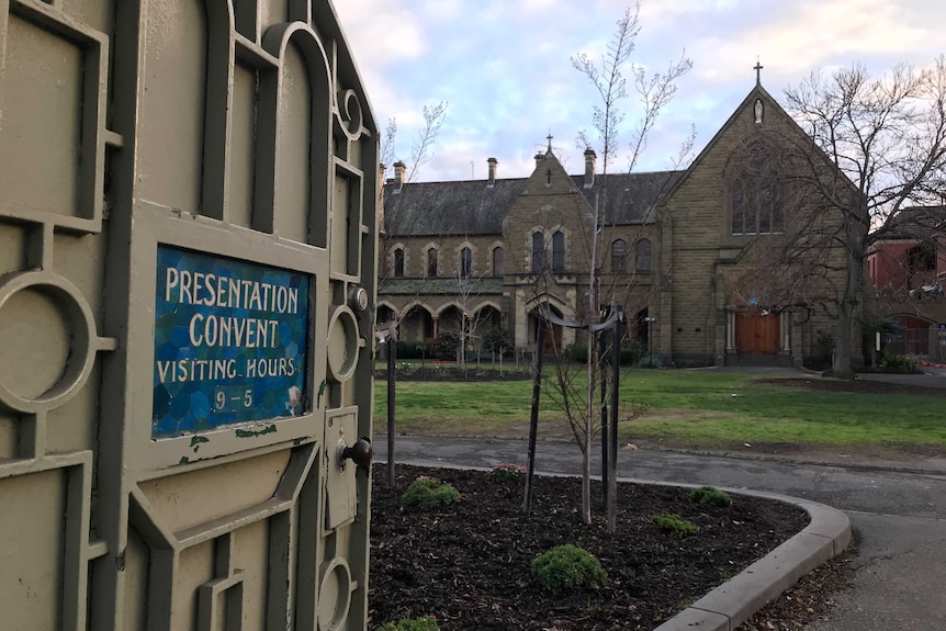 An open gate to the Presentation College buildings bears a sign reading 'Presentation Convent Visiting Hours 9-5'.