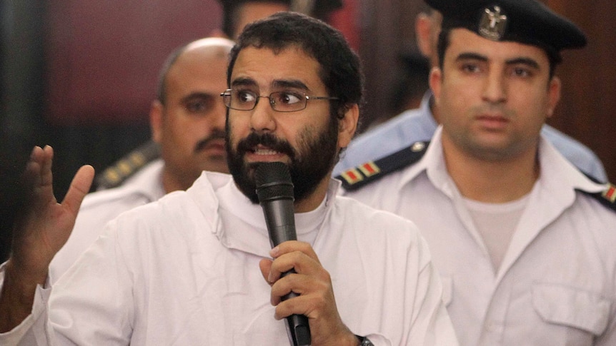 Alaa Abdel Fattah speaks in front of a judge at a court during his 2014 trial