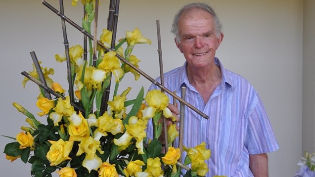 David Ruston with a yellow rose arrangement.