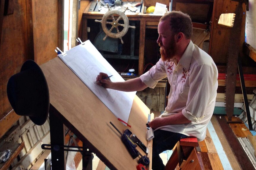 Andrew Christie at his drawing board in the boat.
