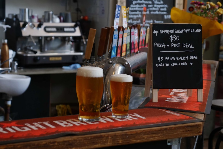 Three beers stand alone on a bar