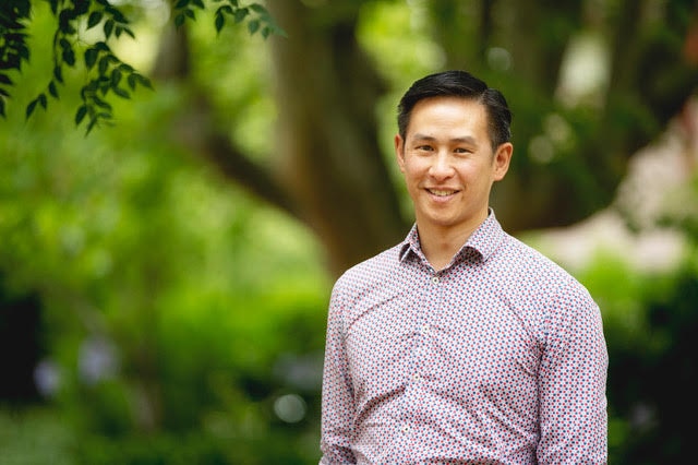 Eugene Wong smiling with trees in background.