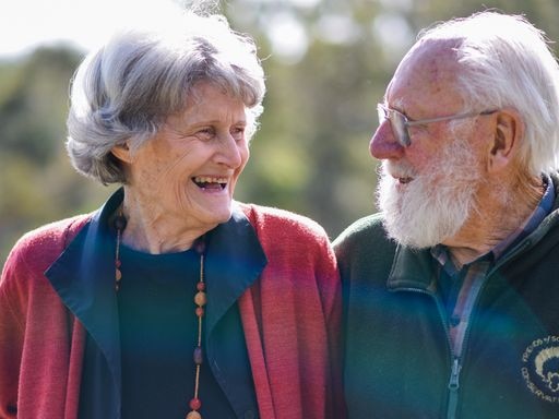 Image of an elderly couple, looking into each other's eyes and smiling.